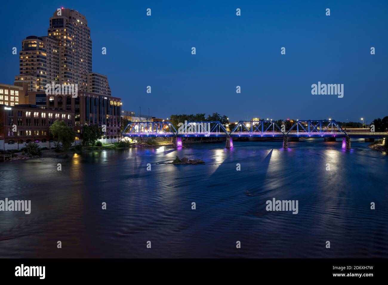 Grand Rapids, Michigan, Stati Uniti: Il Blue Bridge attraversa il Grand River nel centro di Grand Rapids, riflettendo le luci della città durante il crepuscolo serale. Foto Stock