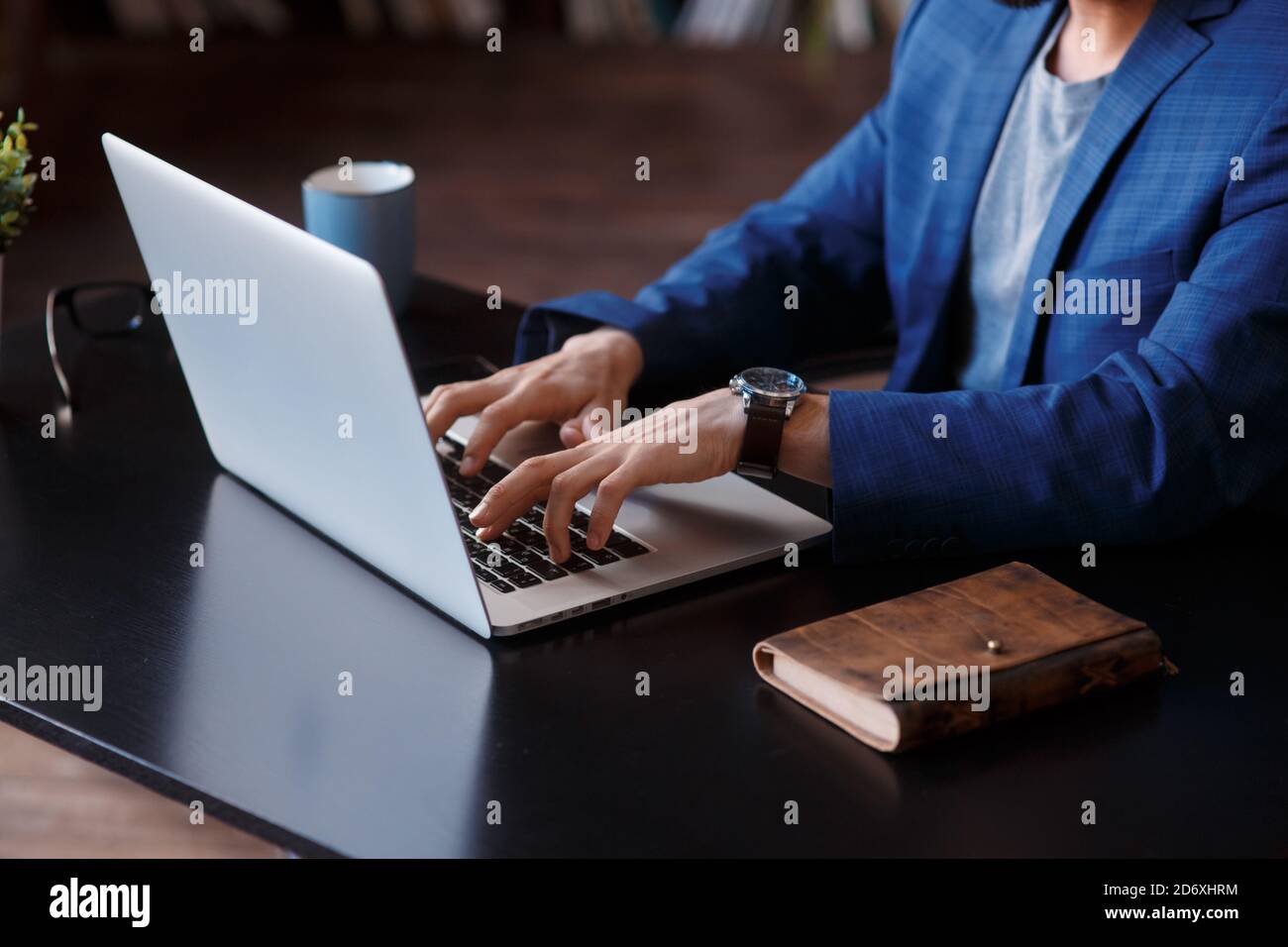 Uomo d'affari che usa un computer portatile a casa. Primo piano di mani maschili che scrivano sulla tastiera del computer portatile in ufficio. Business, lavorare da casa, studiare online Foto Stock