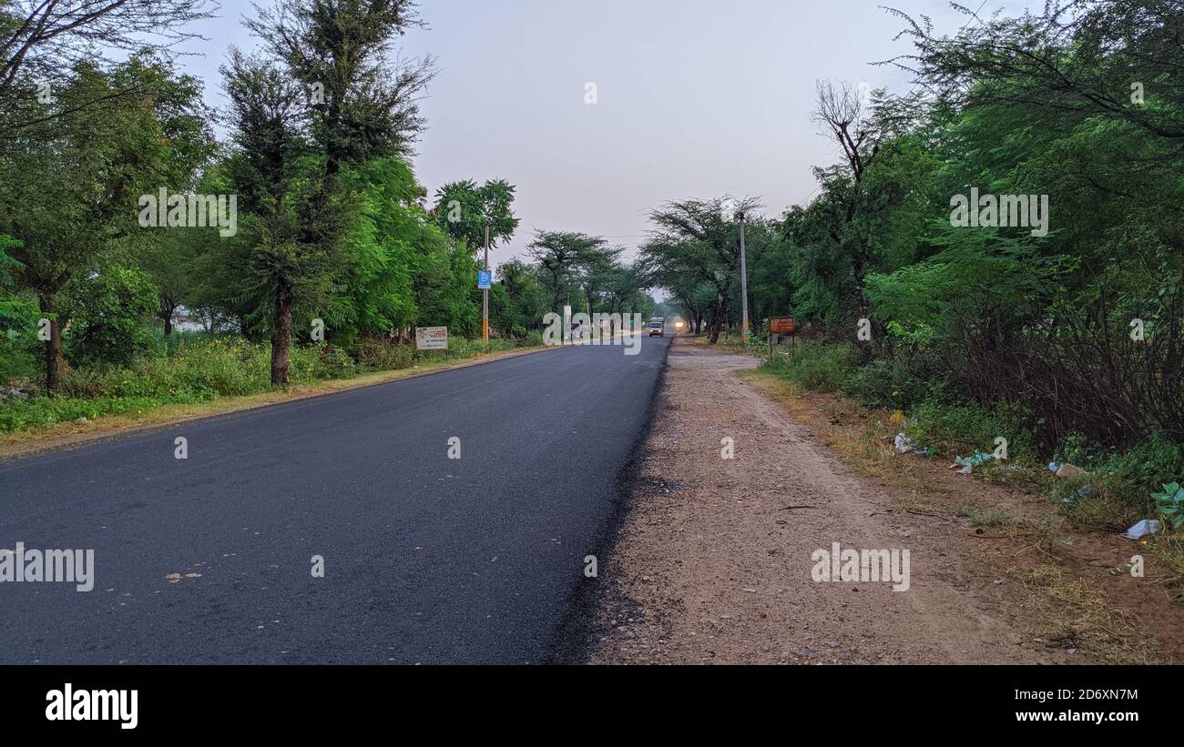 18 Ottobre 2020 : Reengus, Jaipur, India / bella vista creata dalla strada vuota al mattino. Strada vuota che conduce al villaggio e le nuvole bianche Foto Stock