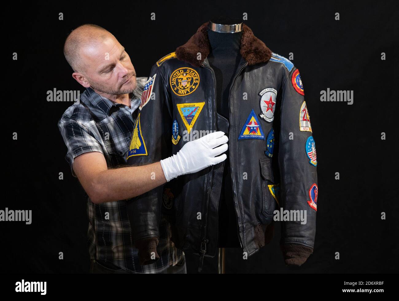 Un dipendente del Prop Store ispeziona la giacca Bomber di Pete 'Maverick'  Mitchell's (Tom Cruise) dal film del 1986 'Top Gun' (stima £12,000-16,000)  durante un'anteprima davanti all'asta di film e cimeli televisivi
