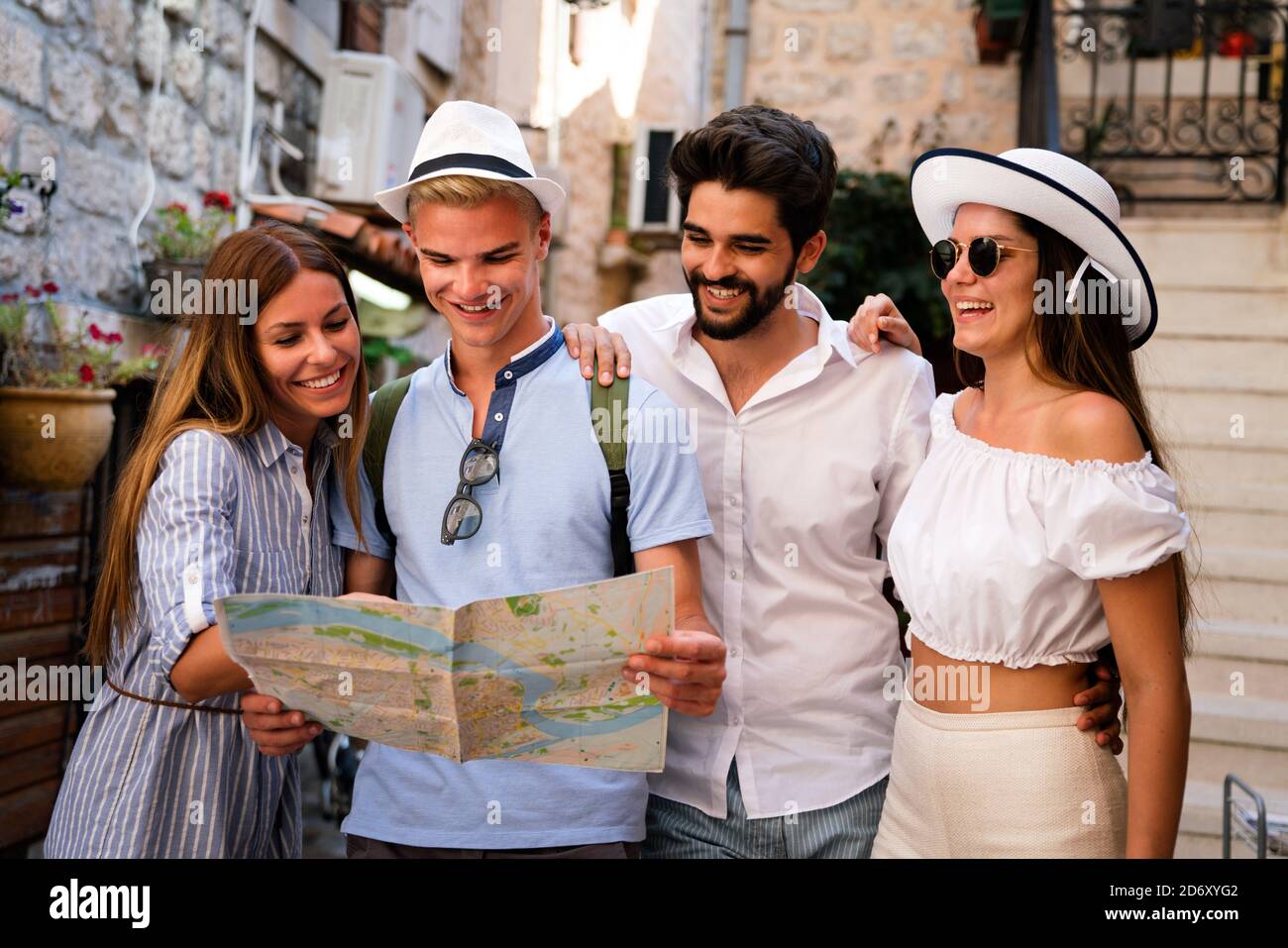 Sorridente girone di amici con la mappa. Turismo, Viaggi, Tempo libero, vacanze e concetto di amicizia Foto Stock