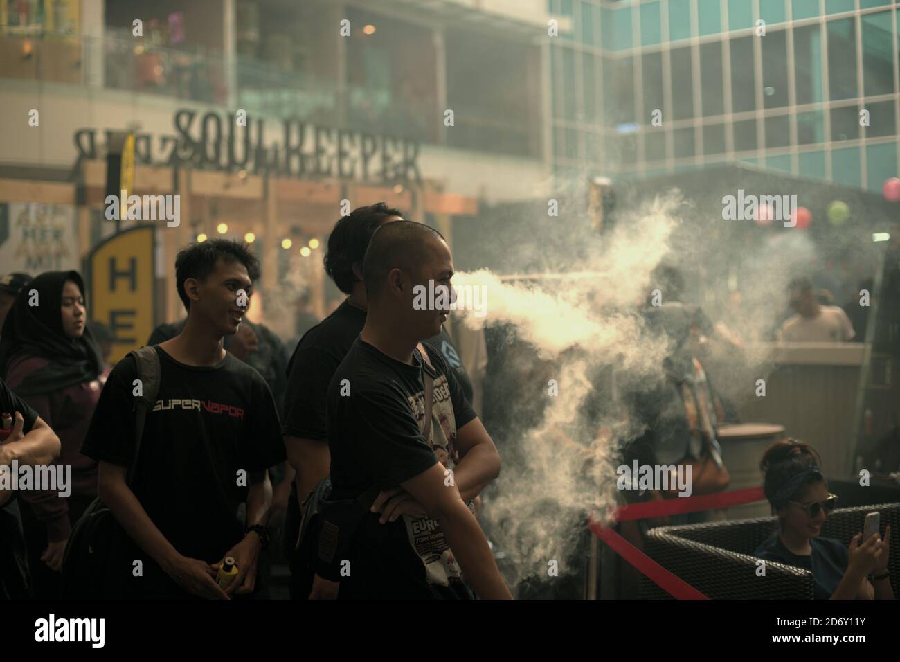 Una folla al backstage di uno degli stand degli espositori durante il Vape Fest, una popolare fiera dell'e-sigaretta che si tiene ogni anno a Giacarta, Indonesia. Le fiere Vaping sono state introdotte in Indonesia dal 2014, attirando decine di migliaia di visitatori ogni volta. Foto Stock