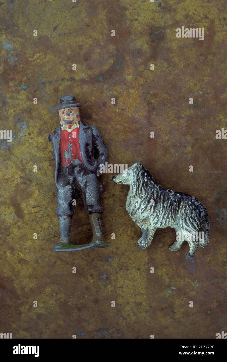 Modelli di piombo vintage martoriati di contadino con braccio mancante in piedi accanto al cane da pastore bianco e nero Foto Stock