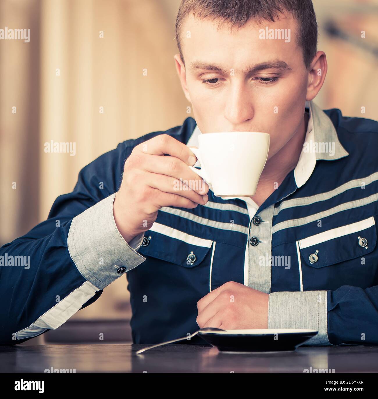 giovane uomo che beve caffè al caffè Foto Stock