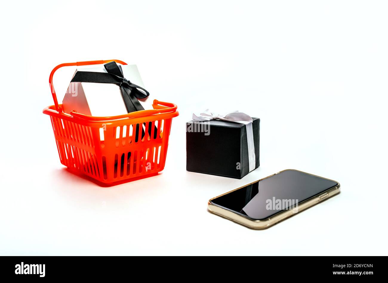 Concetto di shopping online - Carrello della spesa, tablet pc o smartphone, confezione regalo isolata su sfondo bianco. Spazio di copia per il testo. black friday Foto Stock