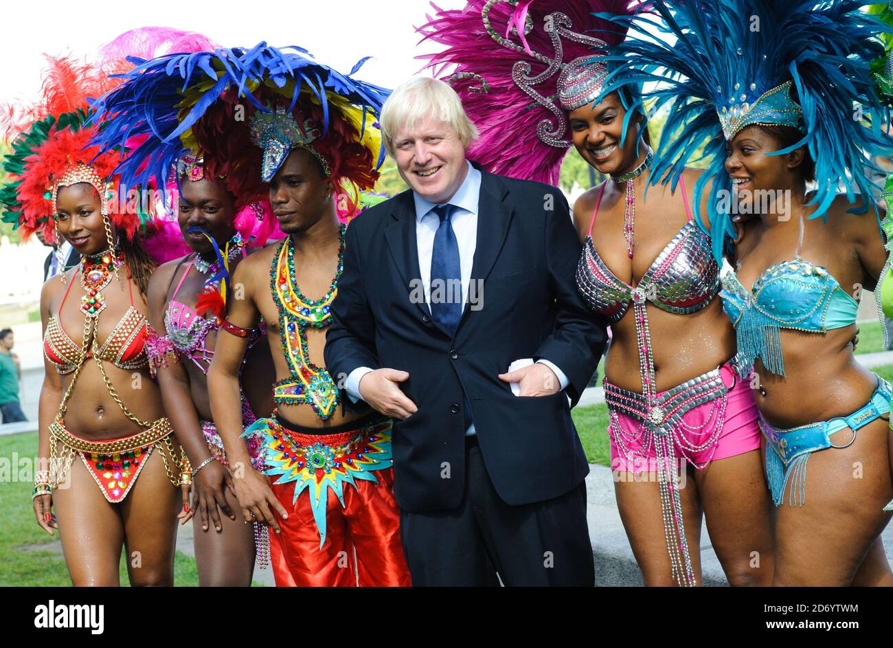 Boris Johnson ha ritratto con i membri della Genesis Mas band, che si esibirà al Notting Hill Carnival questo fine settimana, a Potters Fields nel centro di Londra. Foto Stock
