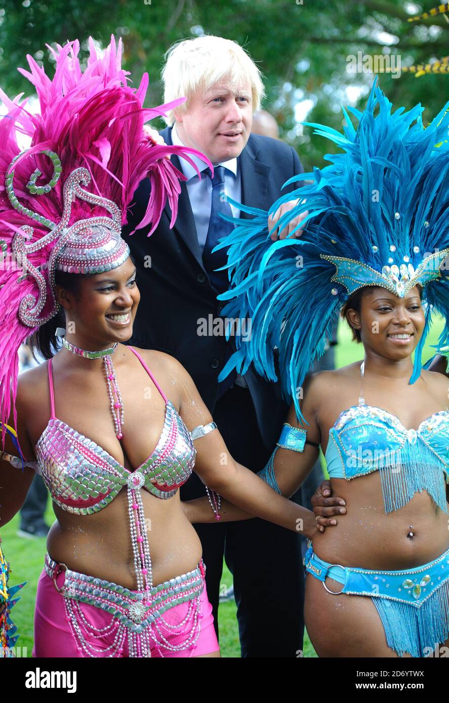 Boris Johnson ha ritratto con i membri della Genesis Mas band, che si esibirà al Notting Hill Carnival questo fine settimana, a Potters Fields nel centro di Londra. Foto Stock