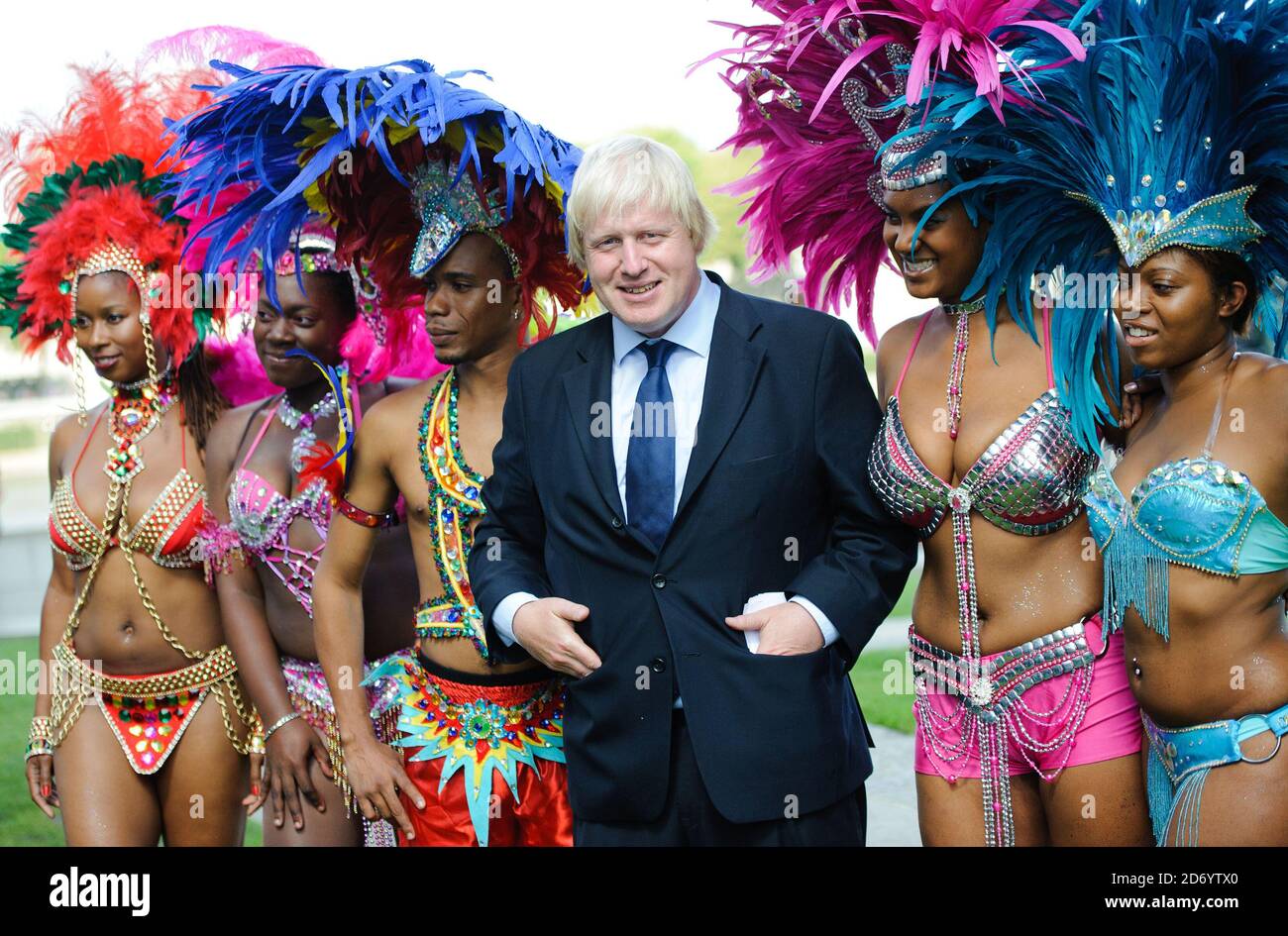 Boris Johnson ha ritratto con i membri della Genesis Mas band, che si esibirà al Notting Hill Carnival questo fine settimana, a Potters Fields nel centro di Londra. Foto Stock