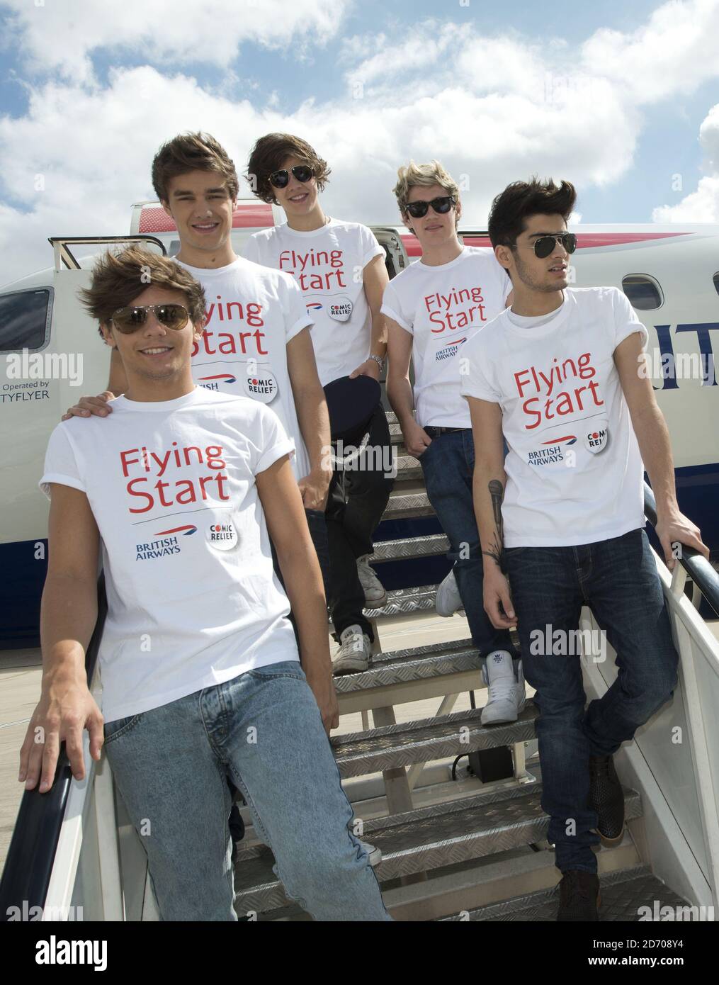 Una direzione (l-r Louis Tomlinson, Liam Payne, Harry Styles, Niall Horan e Zayn Malik) raffigurata prima di imbarcarsi sul volo BA1D - un volo charter privato da Londra a Manchester, ospitato dalla band per i vincitori della competizione, che ha raccolto £50,000 per Flying Start - la partnership benefica di British Airways con Comic Relief. Foto Stock