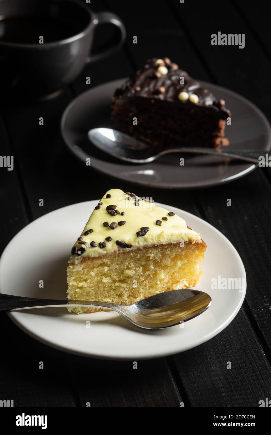 Pezzo di torta al limone e cioccolato sul piatto da dessert sul tavolo nero. Foto Stock