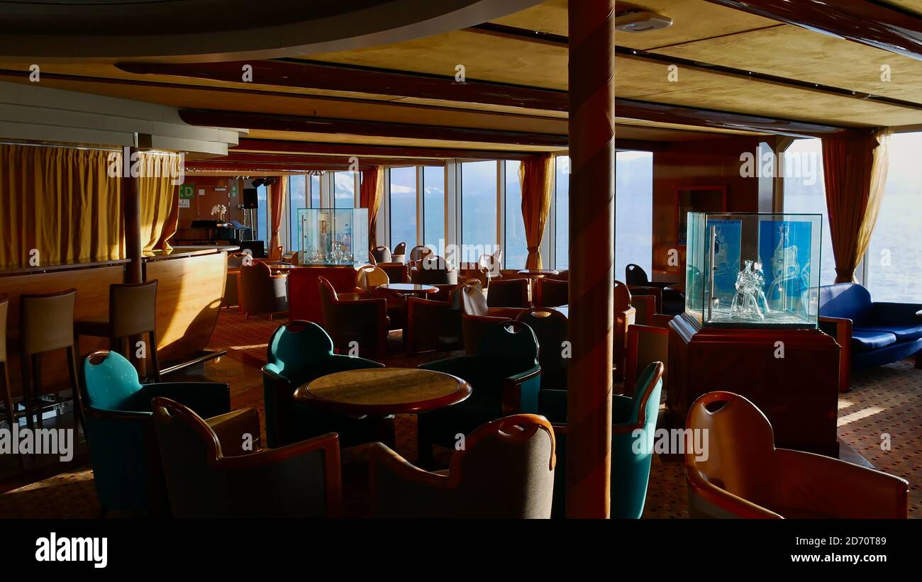Sørøysundet, Norvegia - 03/02/2019: Interior design di un bar sulla nave da crociera Hurtigruten (traghetto RoRo) MS Trollfjord con sedie, tavoli e decorazioni. Foto Stock