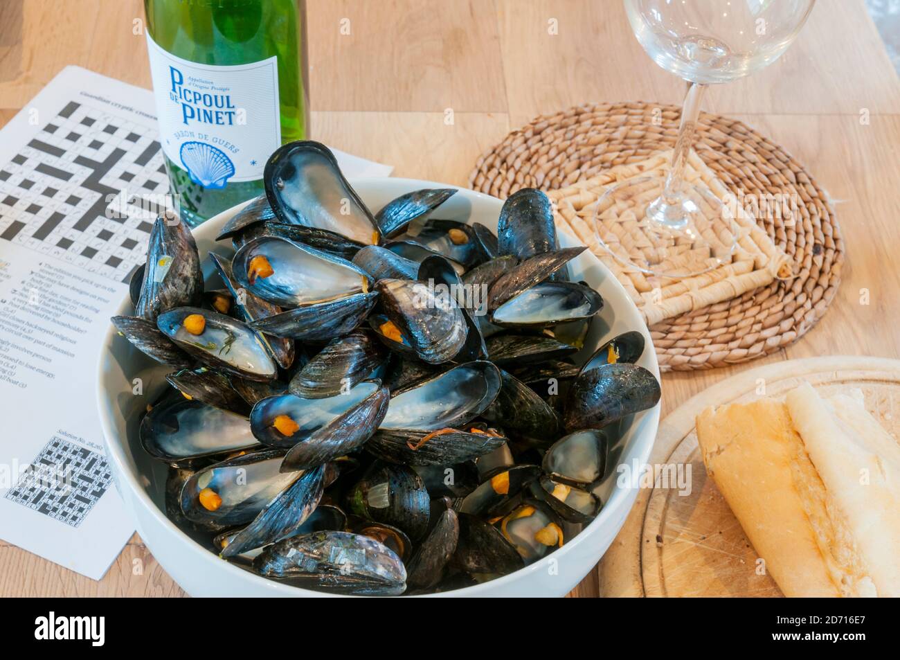La fine di un piacevole pasto a pranzo di Moules Mariniere con conchiglie di cozze vuote e una bottiglia di vino vuota. Foto Stock