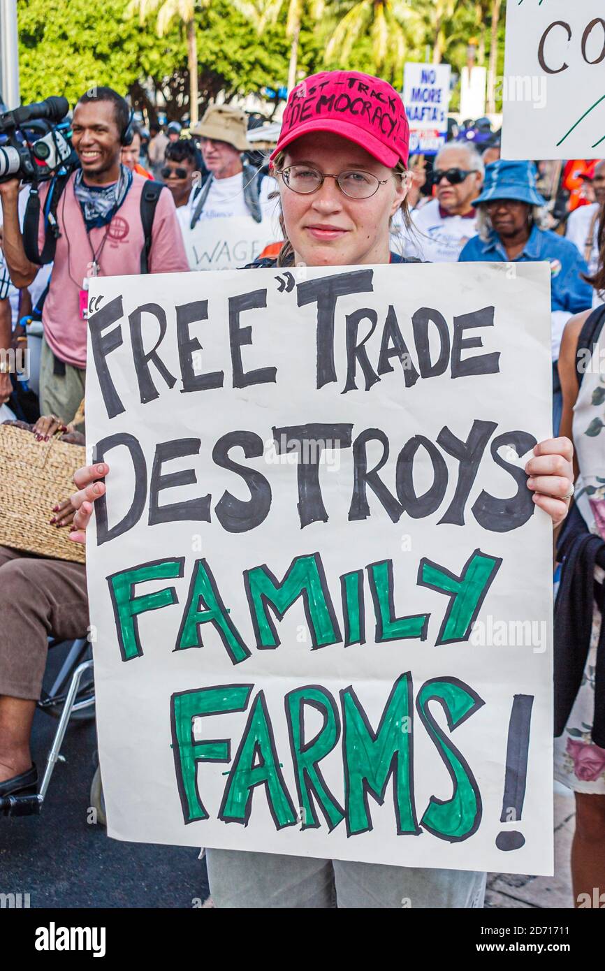 Miami Florida, Biscayne Boulevard, Free Trade Area of Americans Summit FTAA dimostrazioni, donna protesta donna detiene segno di tenuta poster fattoria famiglia Foto Stock