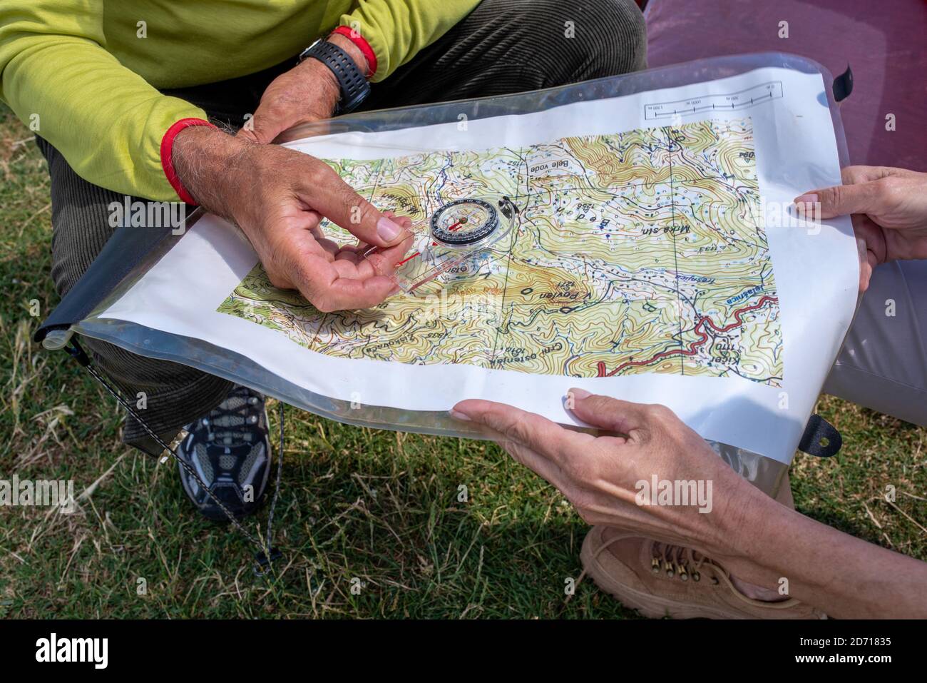 Primo piano di un uomo anziano e di una donna che legge la mappa topografica insieme mentre godendo una giornata nella natura Foto Stock