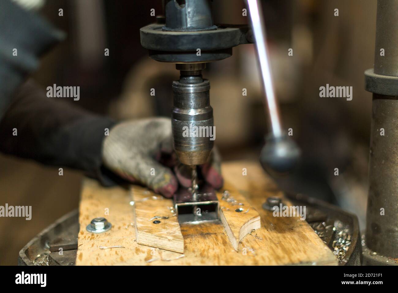 Un lavoratore perfora una parte su una macchina di perforazione Foto Stock