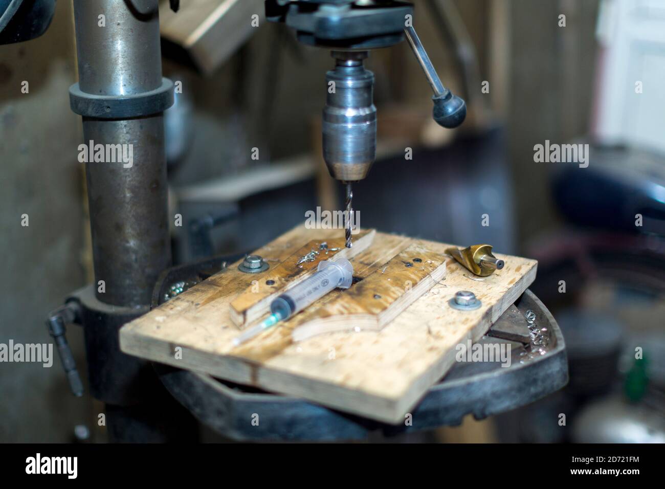 Un lavoratore perfora una parte su una macchina di perforazione Foto Stock