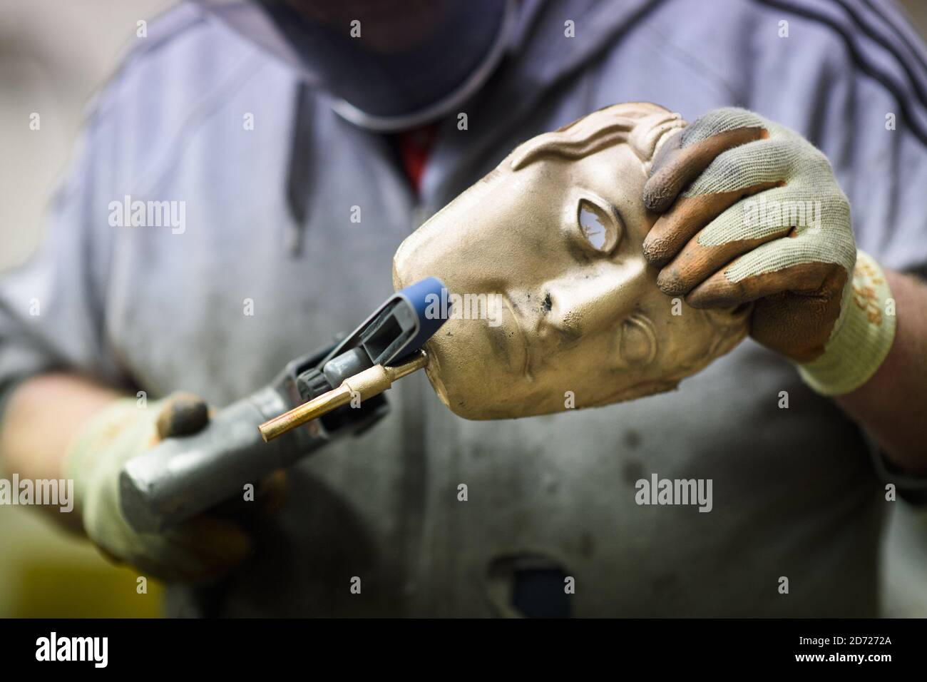 Anthony Phillips Sands and polishes Masks durante la realizzazione dei premi BAFTA, in una fonderia a West Drayton, Middlesex, in vista della cerimonia di premiazione di febbraio. Progettato dallo scultore statunitense Mitzi Cunliffe, New Pro Foundries ha realizzato i calchi in bronzo sin dalla creazione della cerimonia nel 1976. Data immagine: Martedì 31 gennaio 2016. Il credito fotografico dovrebbe essere: Matt Crossick/ EMPICS Entertainment. Foto Stock