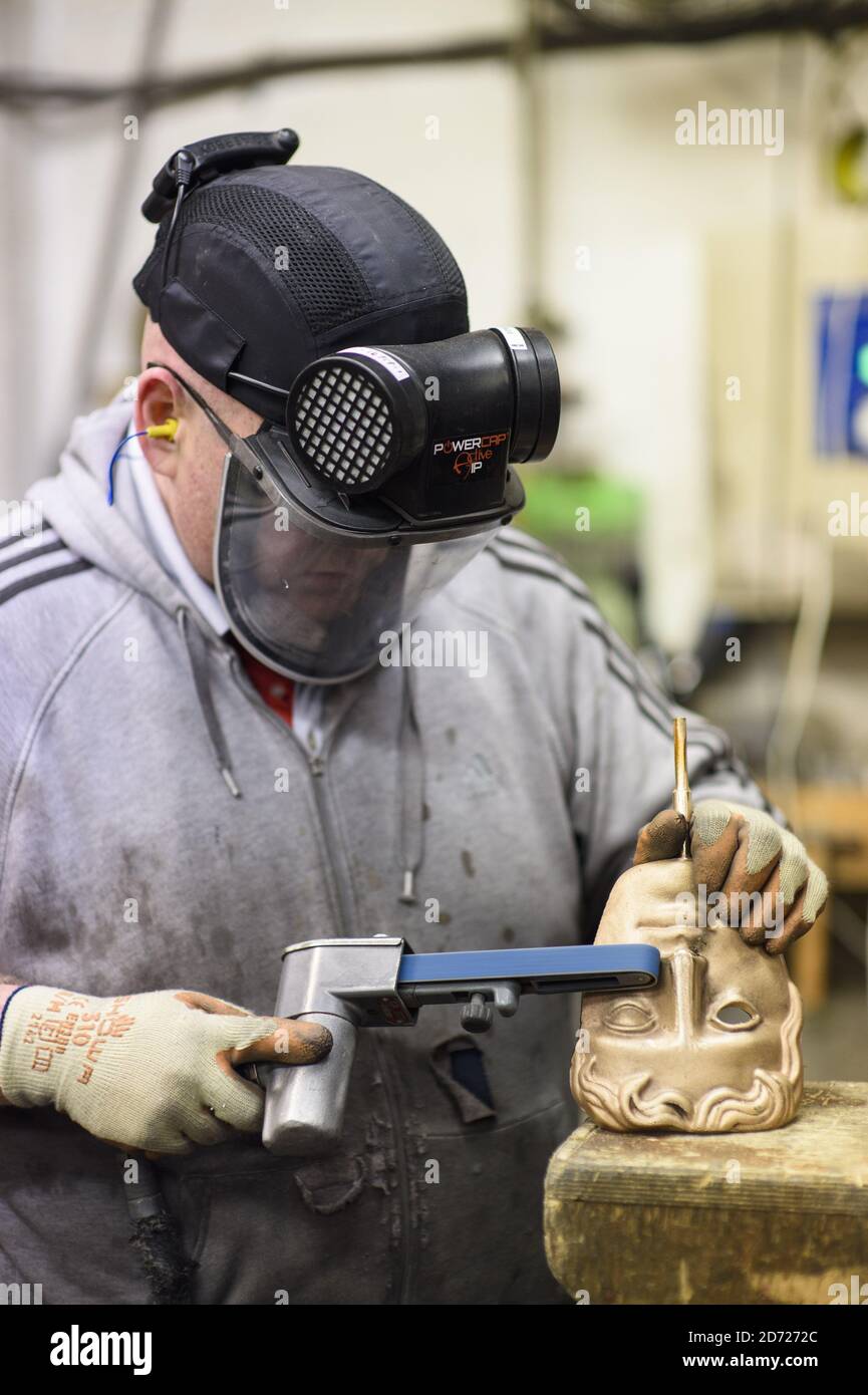 Anthony Phillips Sands and polishes Masks durante la realizzazione dei premi BAFTA, in una fonderia a West Drayton, Middlesex, in vista della cerimonia di premiazione di febbraio. Progettato dallo scultore statunitense Mitzi Cunliffe, New Pro Foundries ha realizzato i calchi in bronzo sin dalla creazione della cerimonia nel 1976. Data immagine: Martedì 31 gennaio 2016. Il credito fotografico dovrebbe essere: Matt Crossick/ EMPICS Entertainment. Foto Stock