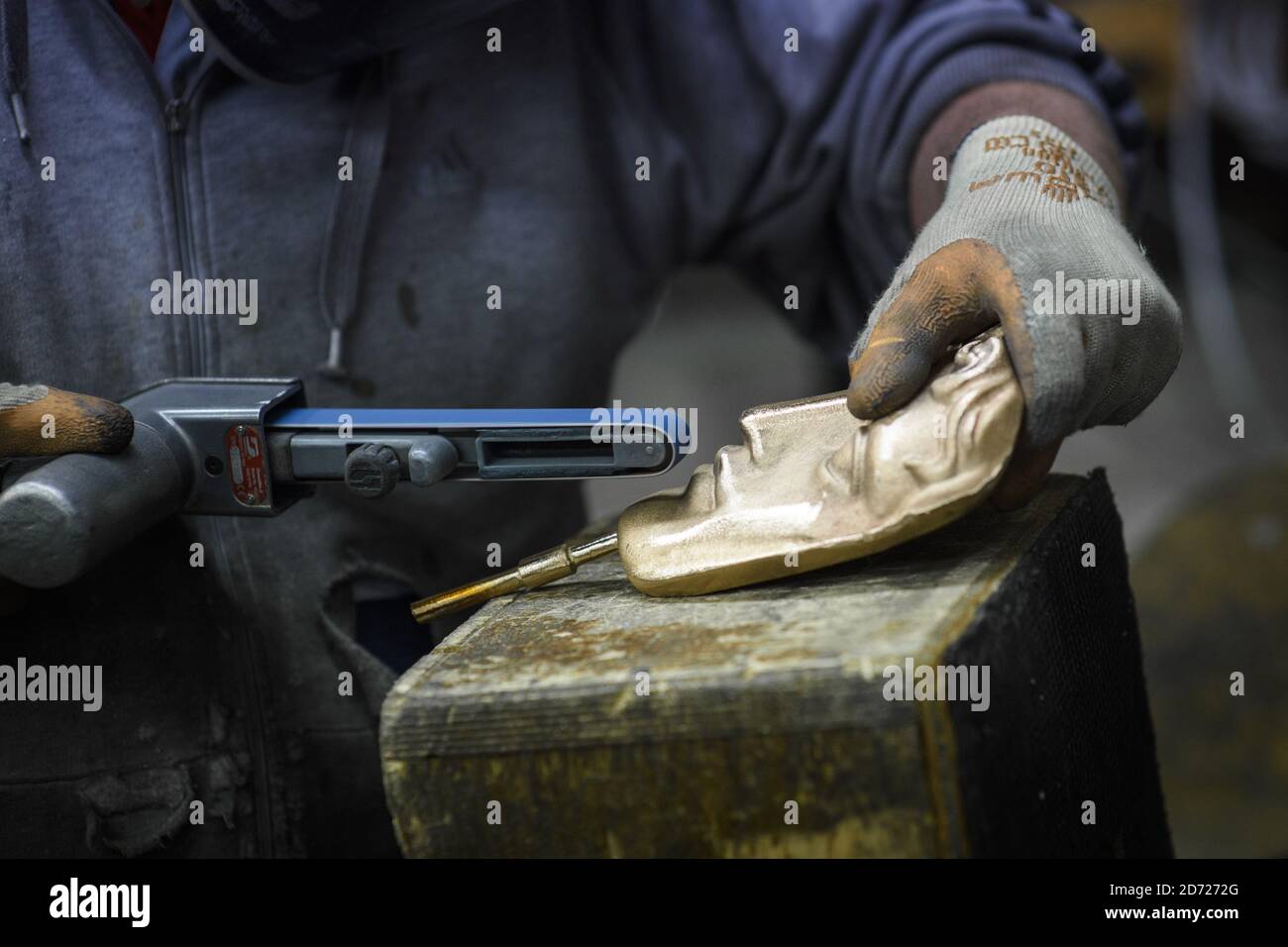 Anthony Phillips Sands and polishes Masks durante la realizzazione dei premi BAFTA, in una fonderia a West Drayton, Middlesex, in vista della cerimonia di premiazione di febbraio. Progettato dallo scultore statunitense Mitzi Cunliffe, New Pro Foundries ha realizzato i calchi in bronzo sin dalla creazione della cerimonia nel 1976. Data immagine: Martedì 31 gennaio 2016. Il credito fotografico dovrebbe essere: Matt Crossick/ EMPICS Entertainment. Foto Stock