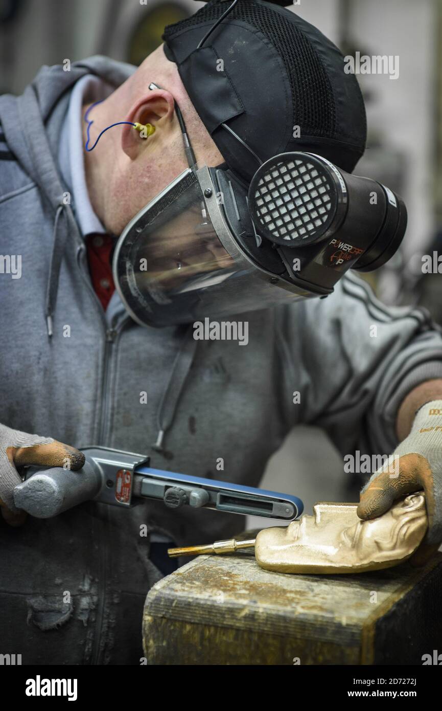 Anthony Phillips Sands and polishes Masks durante la realizzazione dei premi BAFTA, in una fonderia a West Drayton, Middlesex, in vista della cerimonia di premiazione di febbraio. Progettato dallo scultore statunitense Mitzi Cunliffe, New Pro Foundries ha realizzato i calchi in bronzo sin dalla creazione della cerimonia nel 1976. Data immagine: Martedì 31 gennaio 2016. Il credito fotografico dovrebbe essere: Matt Crossick/ EMPICS Entertainment. Foto Stock