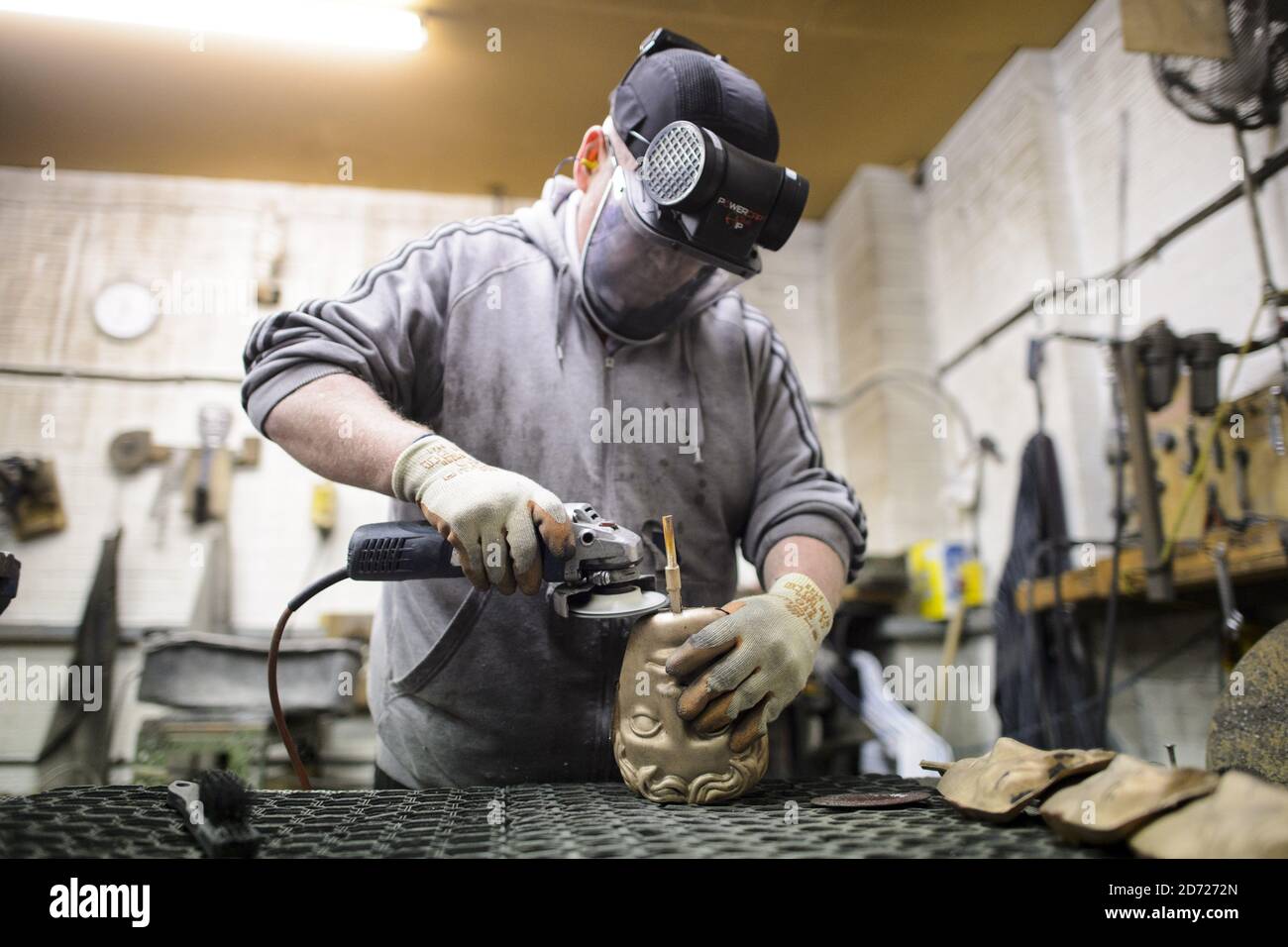 Anthony Phillips Sands and polishes Masks durante la realizzazione dei premi BAFTA, in una fonderia a West Drayton, Middlesex, in vista della cerimonia di premiazione di febbraio. Progettato dallo scultore statunitense Mitzi Cunliffe, New Pro Foundries ha realizzato i calchi in bronzo sin dalla creazione della cerimonia nel 1976. Data immagine: Martedì 31 gennaio 2016. Il credito fotografico dovrebbe essere: Matt Crossick/ EMPICS Entertainment. Foto Stock