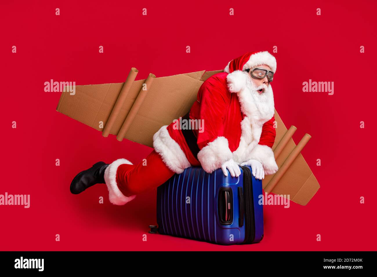 Foto a tutto corpo della barba bianca con nonno infantile ritirata cavalcare il jetpack valigie quasi caduto da cielo usura santa x-mas occhiali da costume Foto Stock