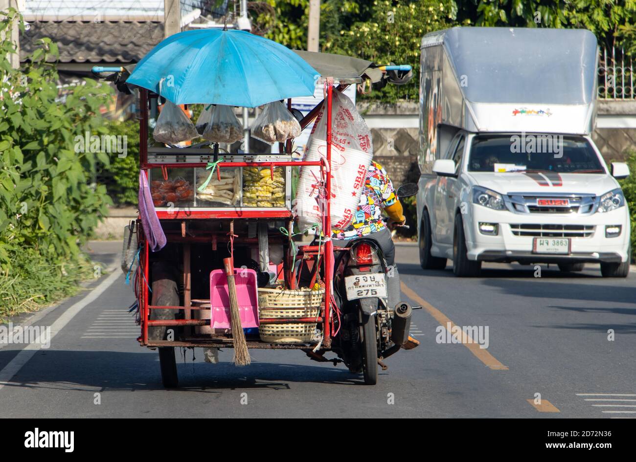 SAMUT PRAKAN, THAILANDIA, GIU 13 2020, un giro del venditore su un triciclo motorizzato su una strada. La stalla mobile di frutta fresca e cibo. Foto Stock