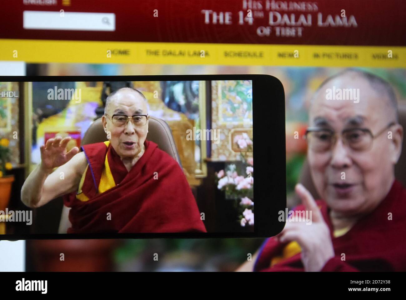 In questa illustrazione fotografica il leader spirituale tibetano il Dalai  lama è visto su uno schermo del telefono cellulare durante un webcast dal  vivo del suo talk show su educare il cuore