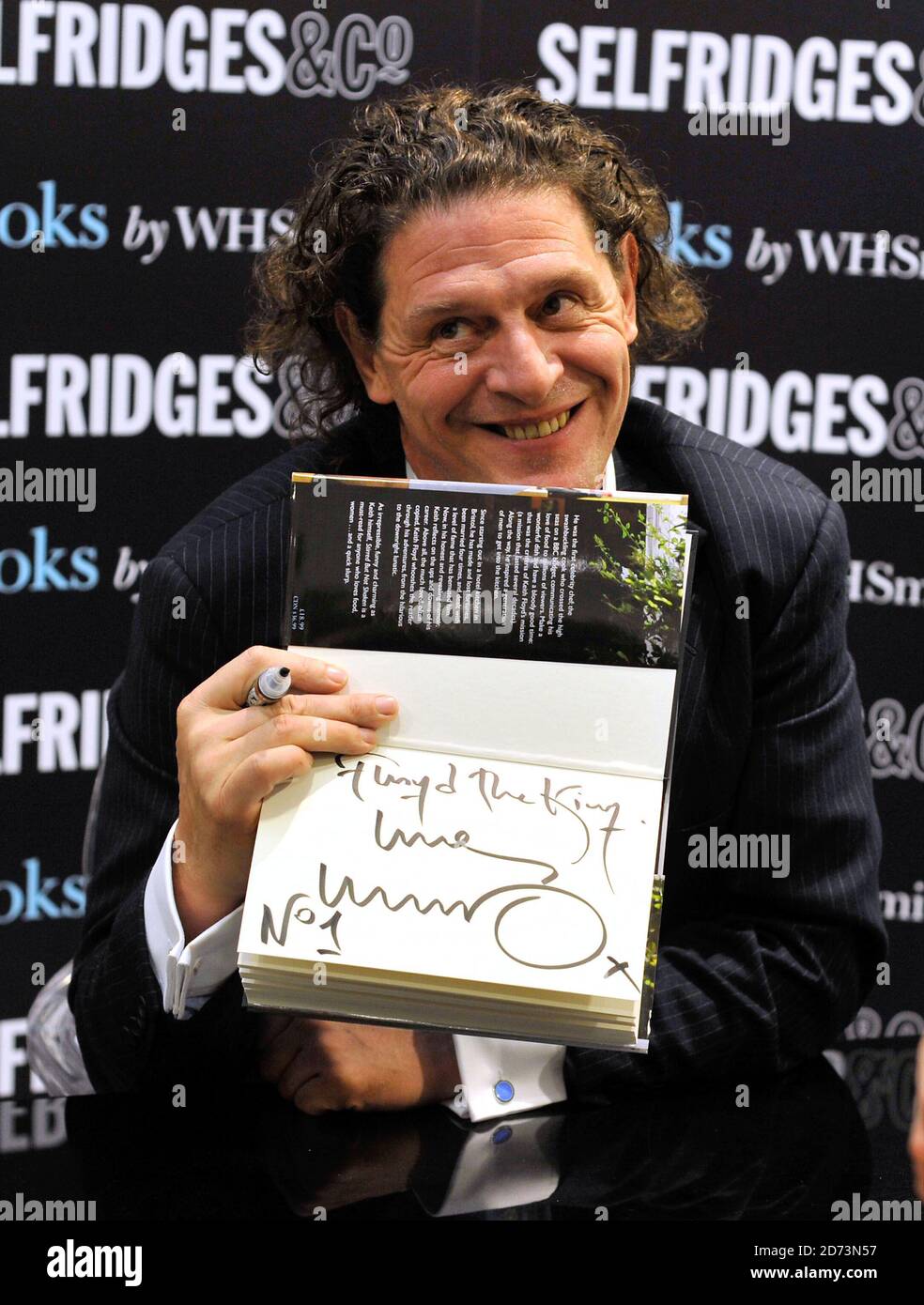 Marco Pierre White firma copie di 'Stirred but not shaken' di Keith Floyd, in omaggio al defunto chef, a Selfridges nel centro di Londra. Foto Stock