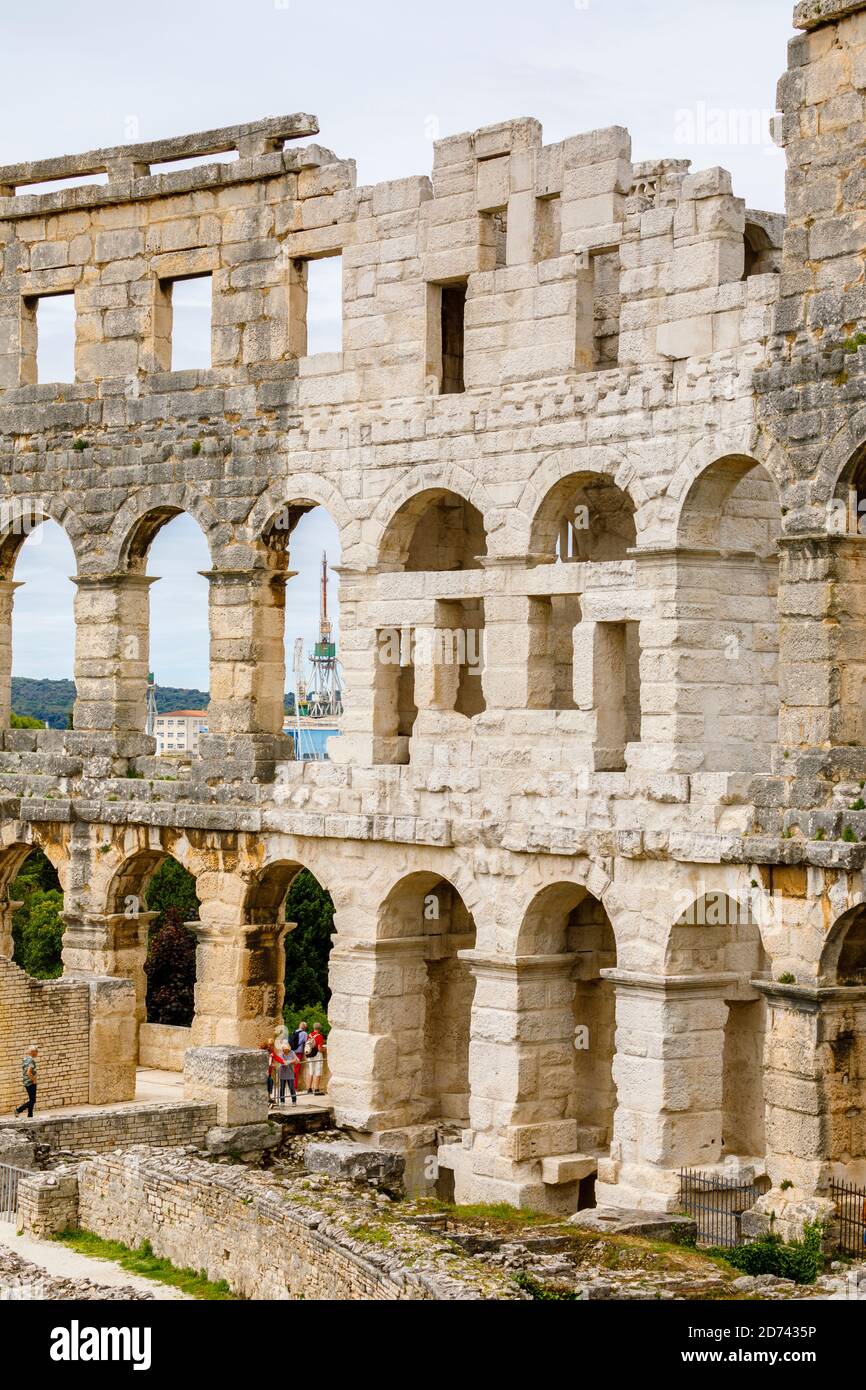Dettagli di archi e colonne nelle pareti esterne dell'iconico antico anfiteatro romano di Pola, Istria, Croazia, una delle principali attrazioni turistiche Foto Stock