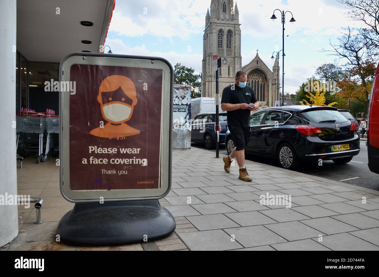 gli acquirenti che lasciano sainsburys indossando maschere facciali passano, si prega di indossare una faccia di copertura richiesta poster muswell hill londra Foto Stock