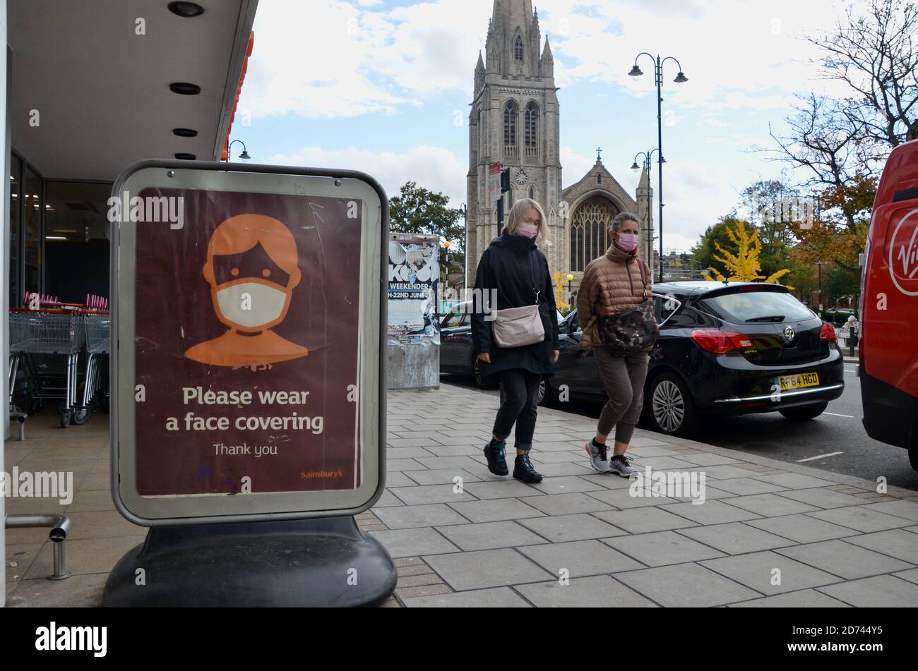 gli acquirenti che lasciano sainsburys indossando maschere facciali passano, si prega di indossare una faccia di copertura richiesta poster muswell hill londra Foto Stock