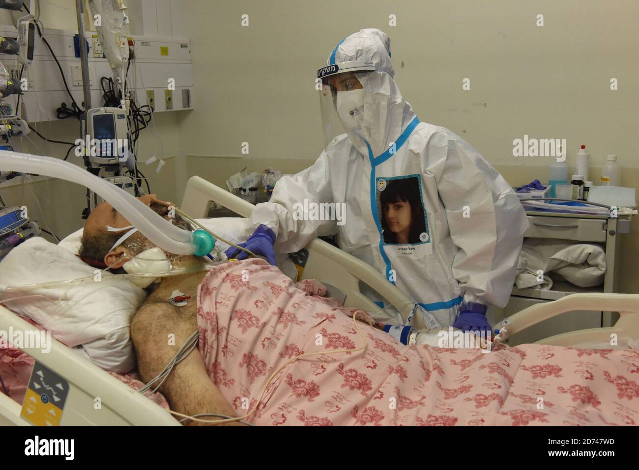 Gerusalemme, Israele. 20 Ott 2020. Un membro dello staff medico israeliano indossa la sua foto sulla parte anteriore della tuta protettiva completa mentre cura un paziente nell'unità di terapia intensiva del reparto COVID-19 nel Centro medico Share Tzedek a Gerusalemme, martedì 20 ottobre 2020. Il governo israeliano ha iniziato ad allentare le restrizioni del coronavirus alla fine di un mese di blocco. Foto di Debbie Hill/UPI Credit: UPI/Alamy Live News Foto Stock