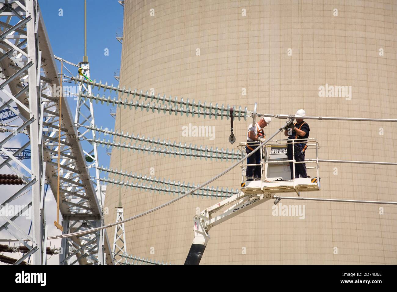 I lavoratori collegano le linee ad alta tensione alla centrale elettrica alimentata a lignite Neurath, vicino a Grevenbroich, Renania settentrionale-Vestfalia, Germania. July2009 arbeiter brin Foto Stock