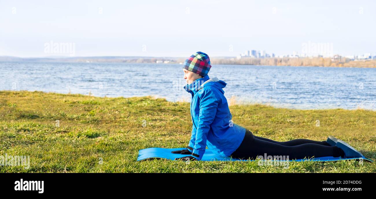 Donna che fa esercizio in outdoor workout in abiti caldi. Foto Stock