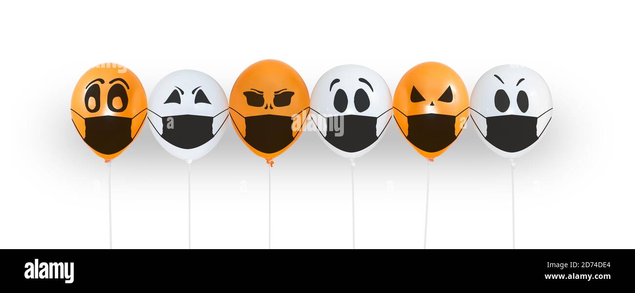 Palloncini colorati con volti in maschera medica per Halloween festa su sfondo bianco. Spazio per il testo. Buona festa ottobre 31. Festa di Halloween Foto Stock
