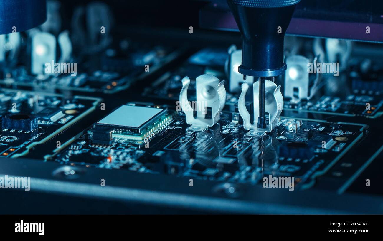 Close-up Macro Shot della macchina elettronica di fabbrica al lavoro: Scheda a circuito stampato in fase di assemblaggio con braccio robotizzato automatizzato, tecnologia Pick and Place Foto Stock