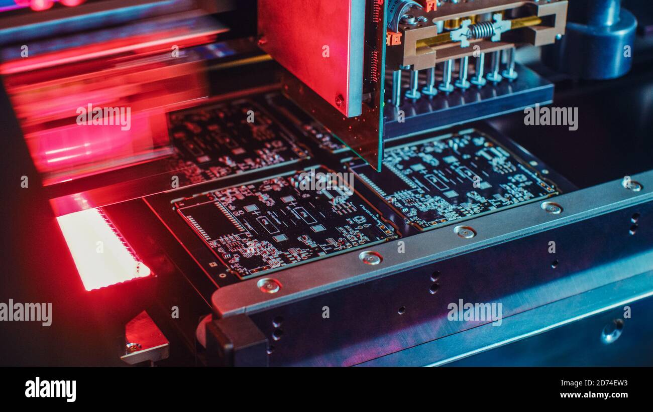 Macchinari in fabbrica: Scheda a circuito stampato assemblata con braccio robotizzato automatizzato, tecnologia a montaggio superficiale che collega i microchip al Foto Stock