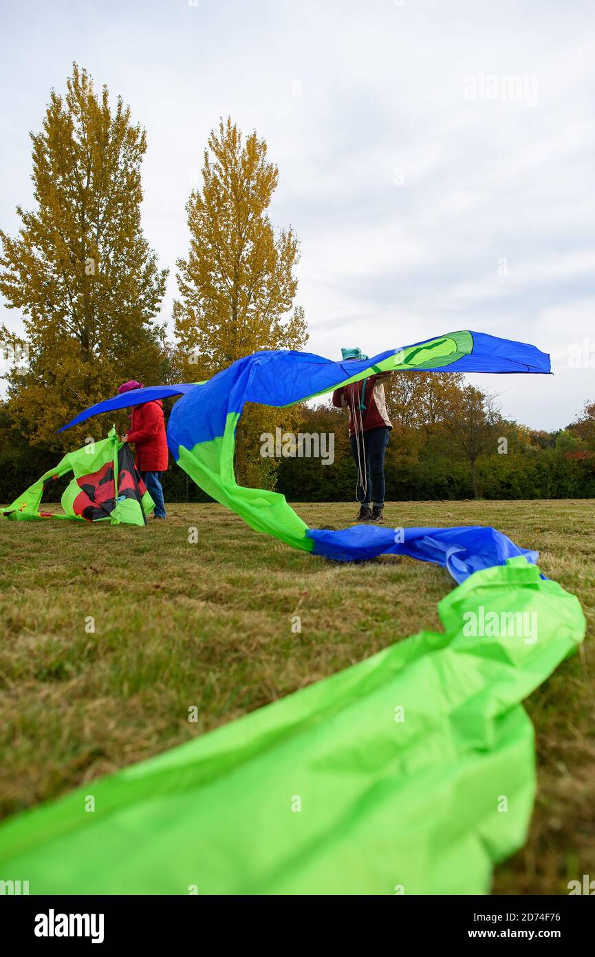 20 ottobre 2020, Sassonia-Anhalt, Magdeburgo: Sabine Dilz (l.) e Jaqueline Wahnschaffe (r.) dagli amici kitei 'Magdeburger Elbwind' preparano i loro aquilz in una zona verde. Gli aquiloni sono progettati e costruiti dagli amici kite stessi. Il gruppo è composto da 9 appassionati di aquiloni con oltre 500 aquiloni. Nei prossimi giorni sarà molto più caldo nella regione intorno alla capitale dello stato, ma ci sarà una brezza leggera costante. Per volare un aquilone avete bisogno di una velocità del vento di almeno uno a tre forze del vento scala Beaufort. Nel mezzo della settimana il vento può essere di 10 chilometri all'ora, che sarebbe sufficiente Foto Stock