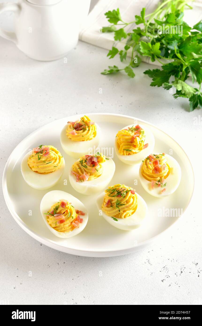 Uova farcite con tuorlo d'uovo, pancetta, senape e aneto, vista ravvicinata Foto Stock