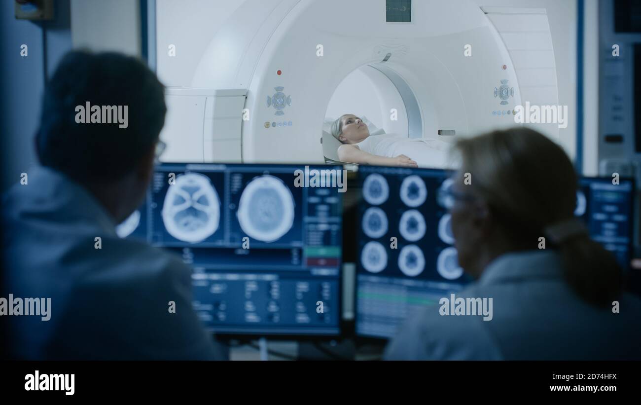 Nel laboratorio medico il paziente viene sottoposto a un processo di scansione RM o TC sotto la supervisione di un medico e di un radiologo nella sala di controllo, la procedura di monitoraggio e. Foto Stock
