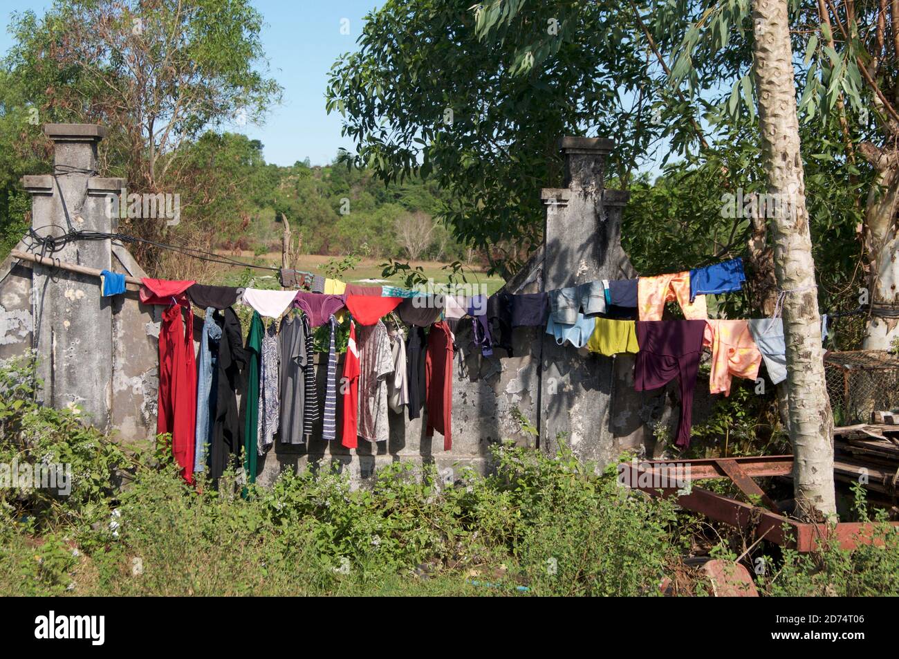 Vista di molti abiti colorati appesi su una linea di lavaggio Nel villaggio di Otres Beach in Cambogia su un giorno di sole Foto Stock