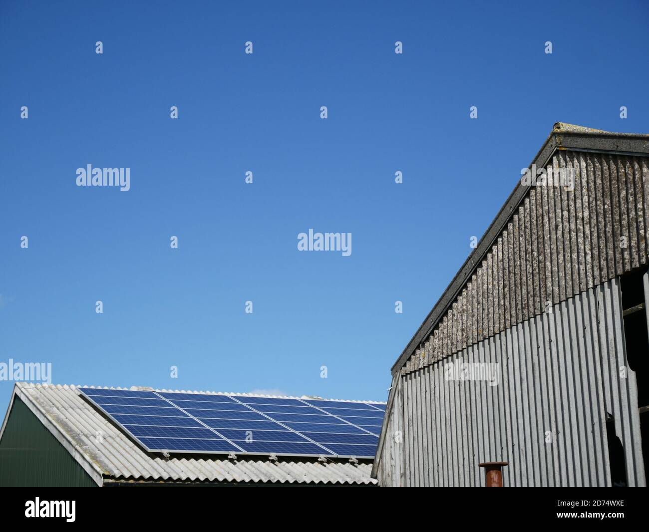 Pannelli solari su un tetto di costruzione di fattoria offrono un altro reddito flusso per attività agricole rurali diversificate Foto Stock