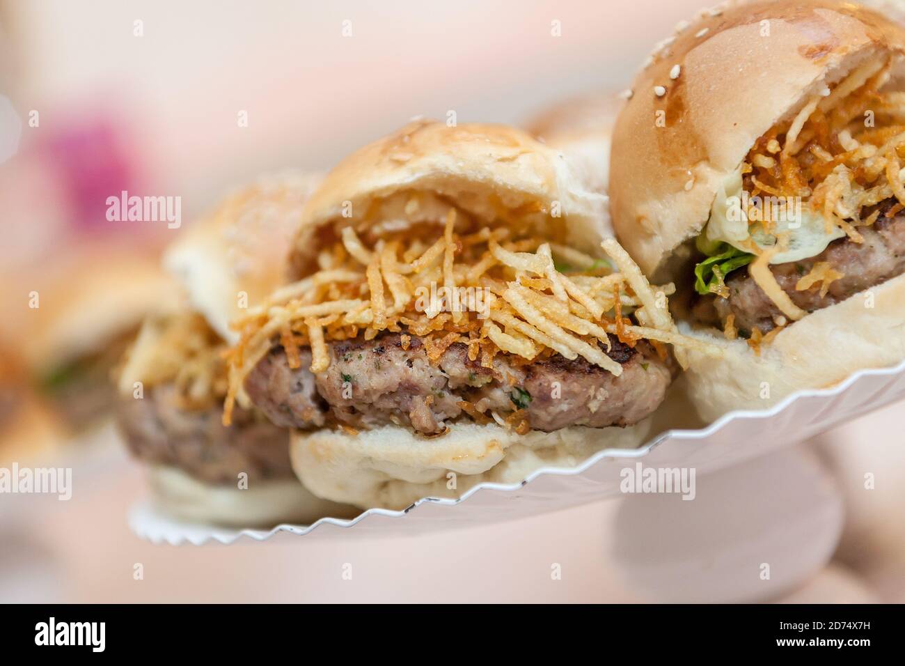 Primo piano di un piccolo hamburger americano, con prosciutto, patatine fritte. Antipasto di festa. Foto Stock