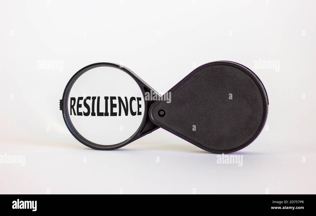 Lente d'ingrandimento con la parola "resilienza" su uno sfondo bianco bellissimo. Concetto aziendale, spazio di copia. Foto Stock