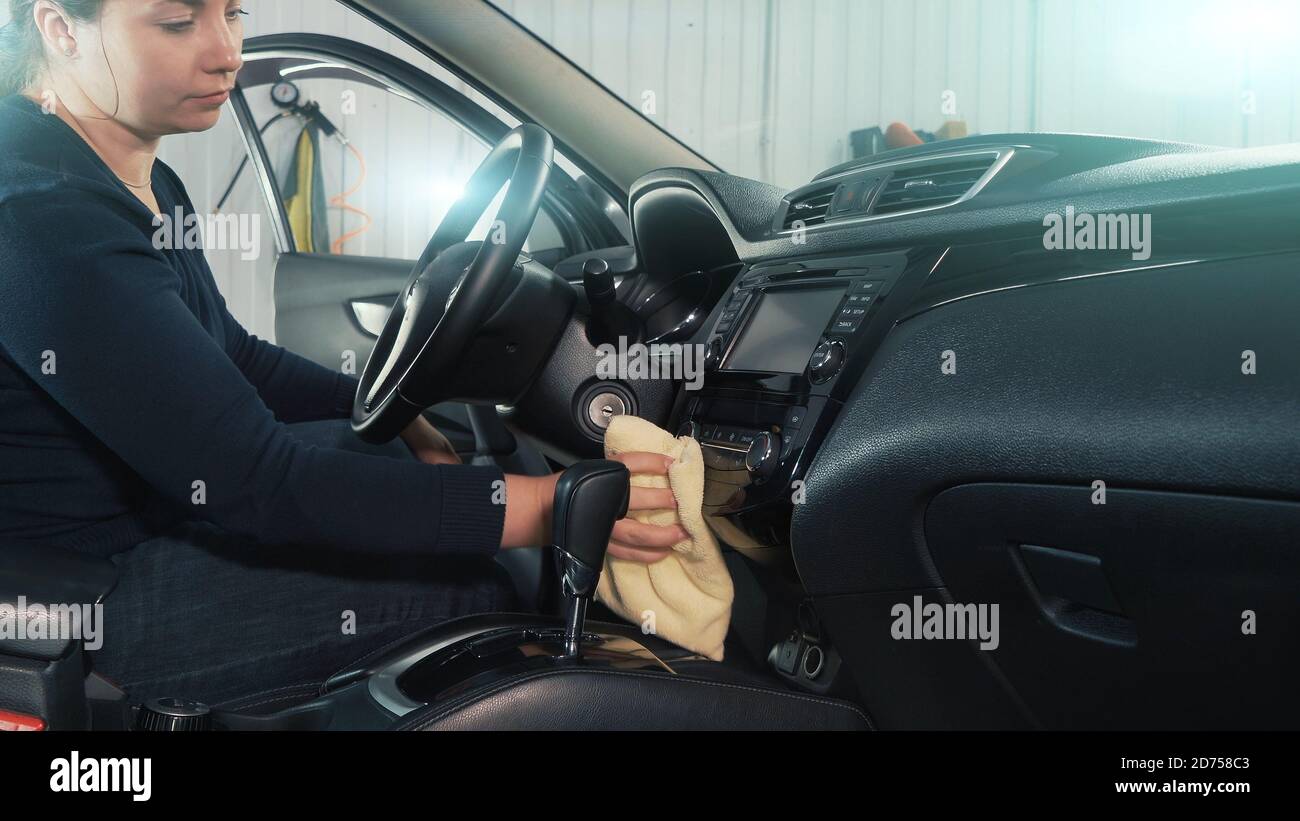 Donna professionale auto lavaggio e disinfezione interni auto con asciugamano in microfibra. Concetto di dettaglio dell'auto. Foto Stock