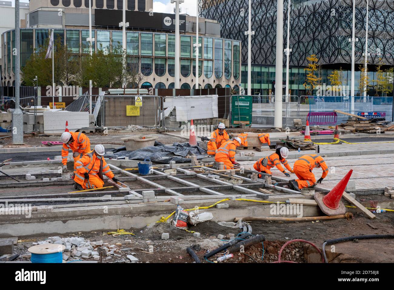 Lavoratori edili che costruiscono binari per la metropolitana West Midlands lungo Broad Street a Birmingham, Regno Unito Foto Stock