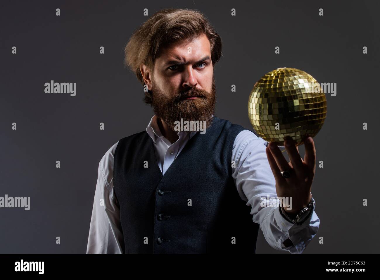 L'uomo maturo bearded tiene la sfera dorata della discoteca, il concetto di vita di notte. Foto Stock