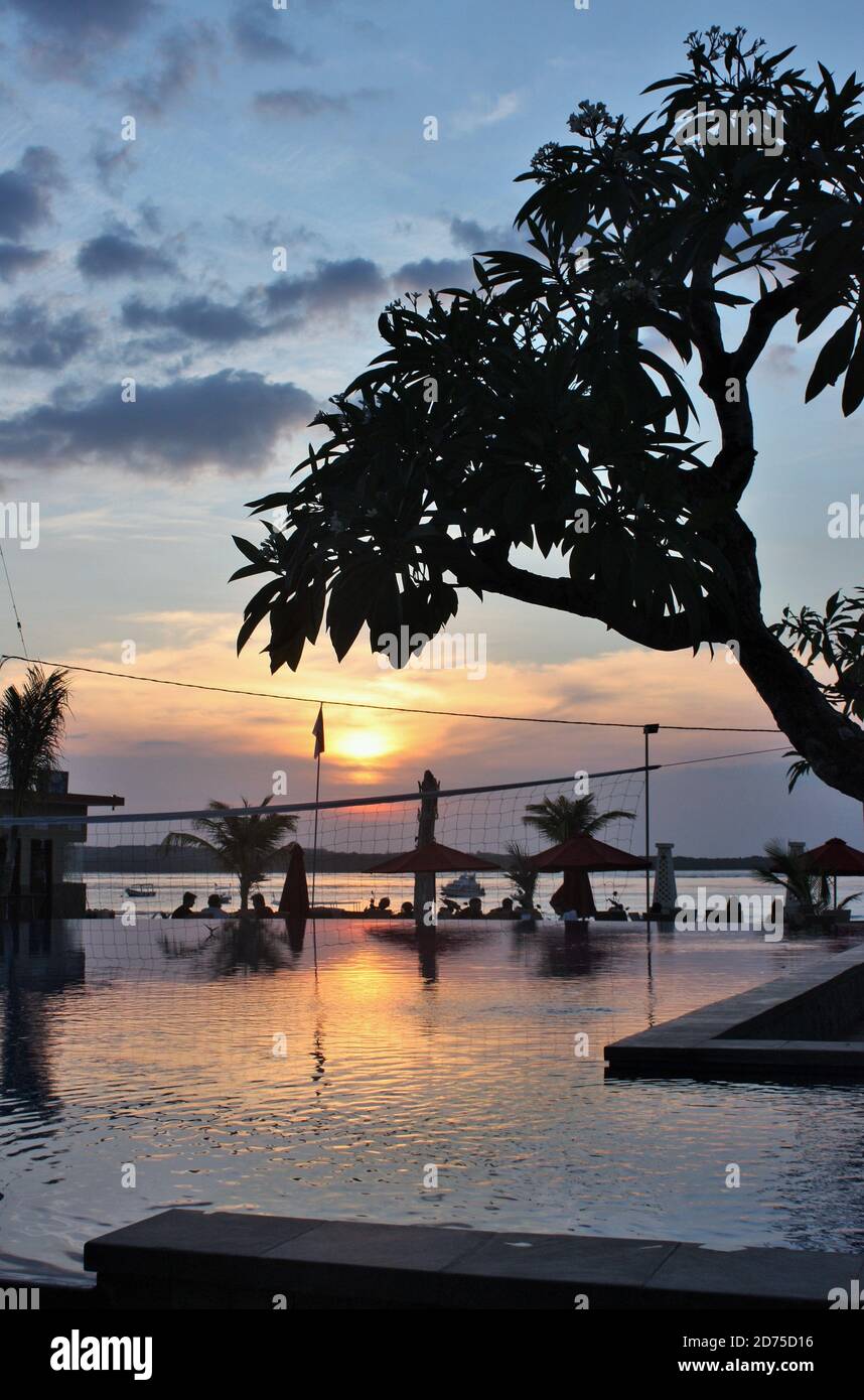 Riflesso del tramonto in piscina infinity vicino al mare Foto Stock