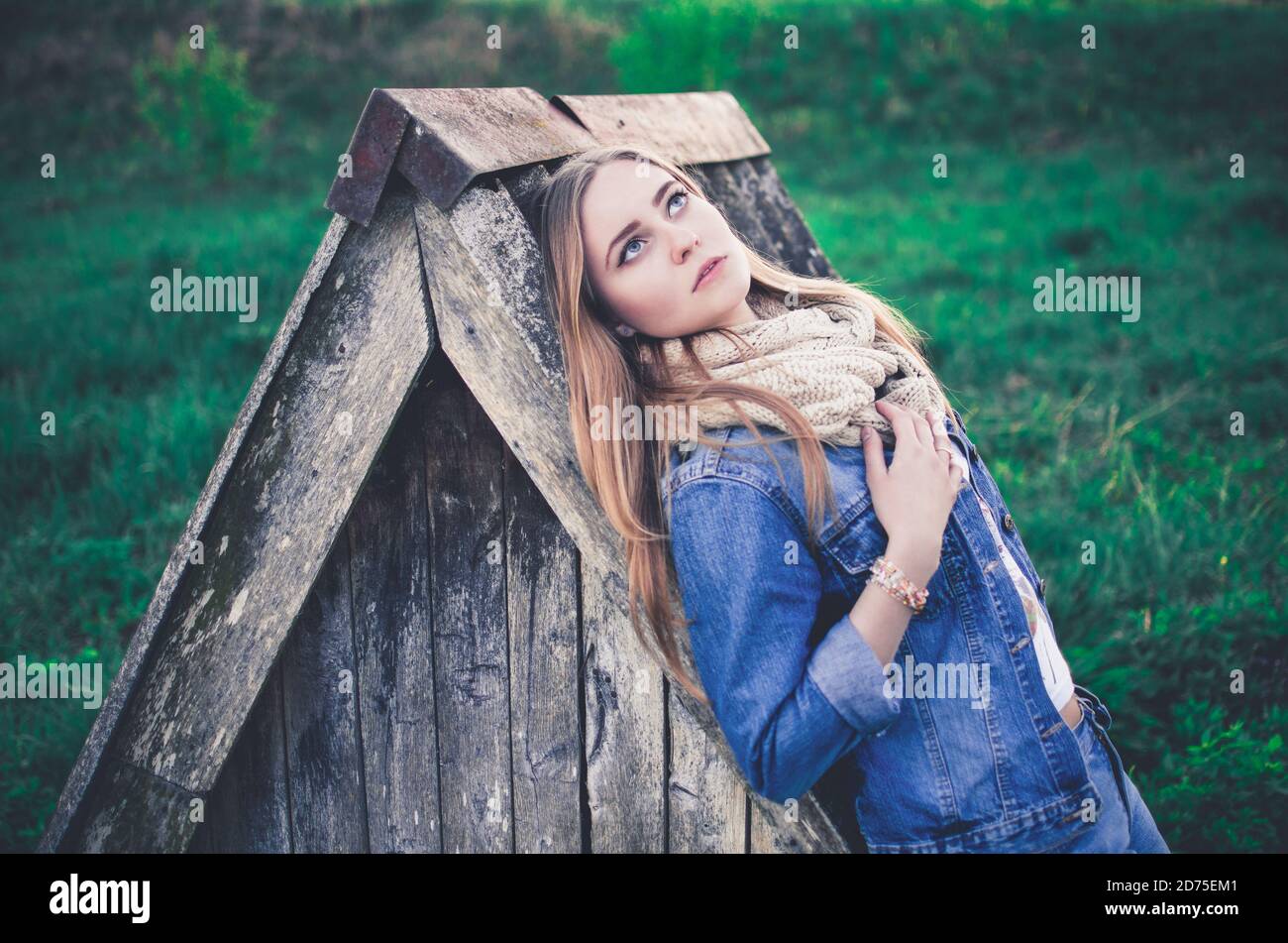 giovane donna europea bionda in jeans blu e lavorato a maglia sciarpa all'aperto Foto Stock